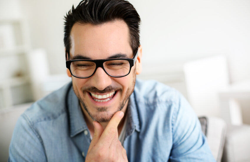 A man grabbing his jaw, smiling after TMJ treatment in Chattanooga.