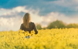 Woman standing in a field facing away from the camera