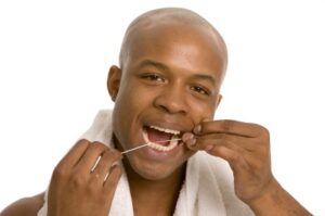 A man using dental floss to prevent gum diesease in Chattanooga.