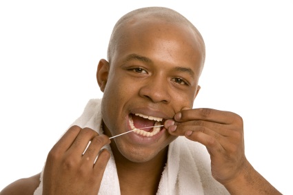 A man using dental floss to prevent gum diesease in Chattanooga.