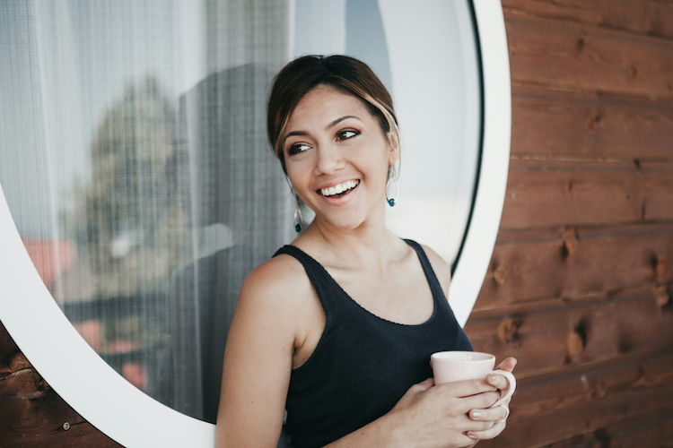 Smiling female dental patient enjoys a cup of coffee in Chattanooga, NT