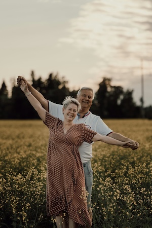 Dental implant dentures patients smiling and dancing in a field in Chattanooga, TN