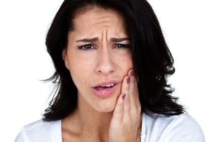A young woman clutching her jaw from untreated TMJ in Chattanooga.